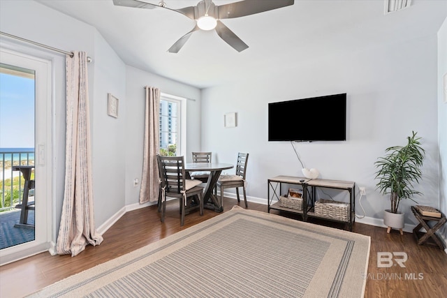 dining room with dark wood-type flooring, a ceiling fan, visible vents, and baseboards