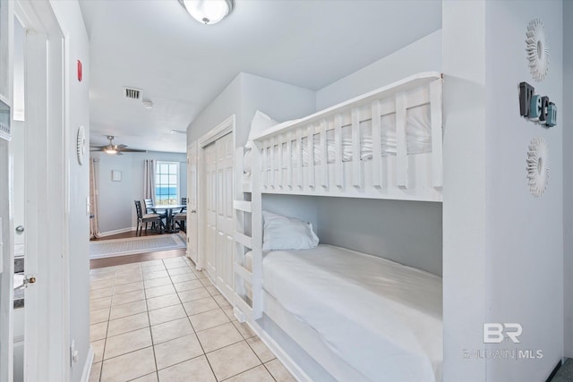 tiled bedroom featuring a closet and visible vents