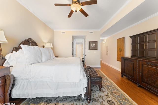 bedroom with crown molding, light hardwood / wood-style floors, and ceiling fan