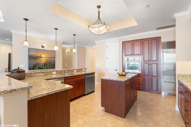 kitchen featuring pendant lighting, stainless steel appliances, light tile flooring, a tray ceiling, and light stone counters