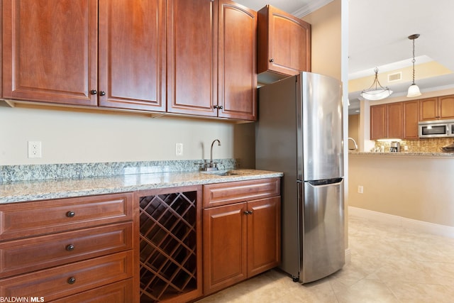 kitchen featuring pendant lighting, light tile floors, light stone countertops, appliances with stainless steel finishes, and sink