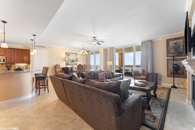 living room featuring crown molding, light tile floors, and ceiling fan with notable chandelier