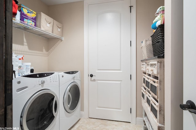 laundry room featuring light tile flooring and separate washer and dryer