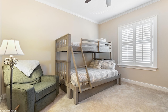 carpeted bedroom with ornamental molding and ceiling fan