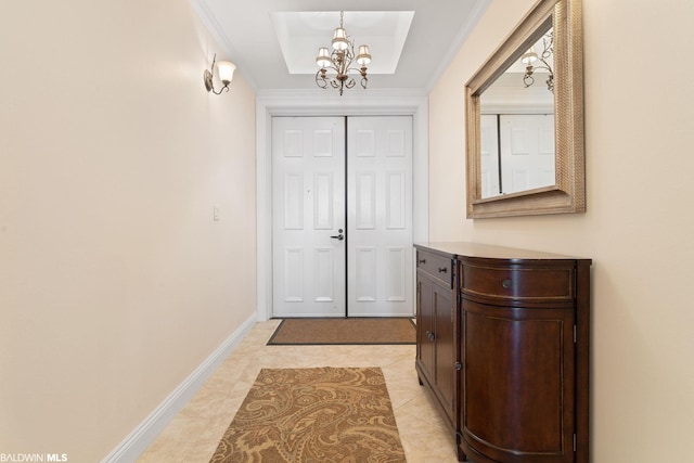 entryway with light tile floors, a notable chandelier, and a tray ceiling