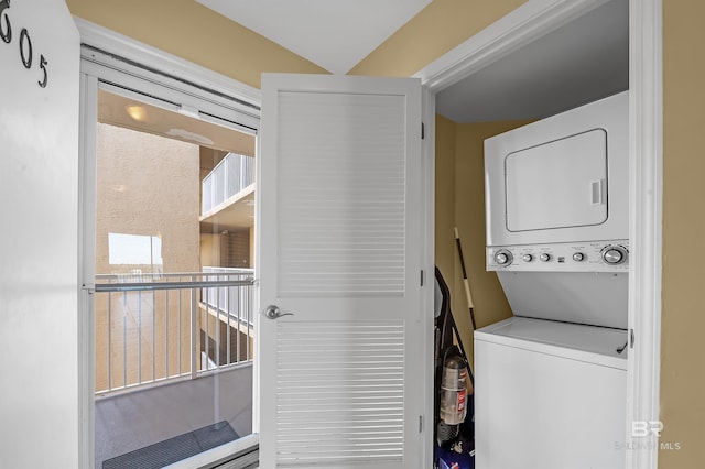 washroom featuring stacked washer / drying machine and laundry area