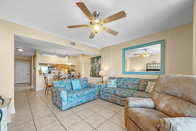 living area featuring visible vents, ceiling fan, baseboards, and light tile patterned floors