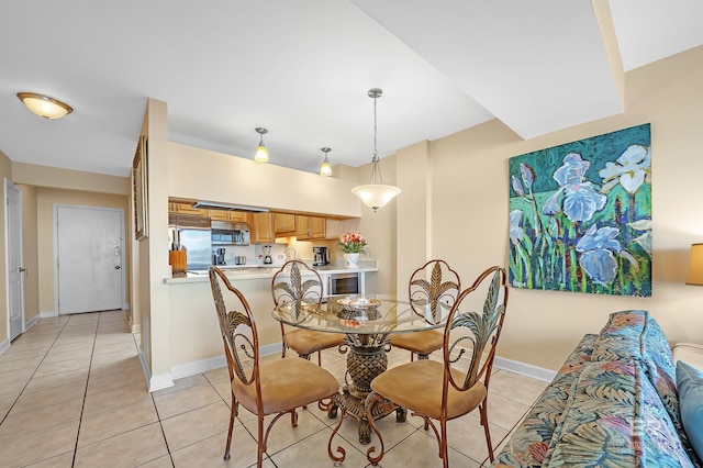 dining space featuring light tile patterned flooring and baseboards