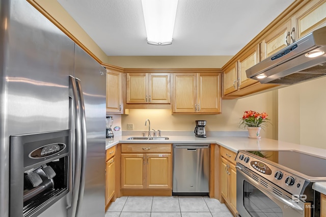 kitchen with stainless steel appliances, a sink, light countertops, and under cabinet range hood