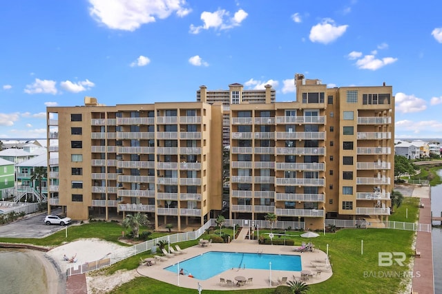 view of property featuring a community pool and fence