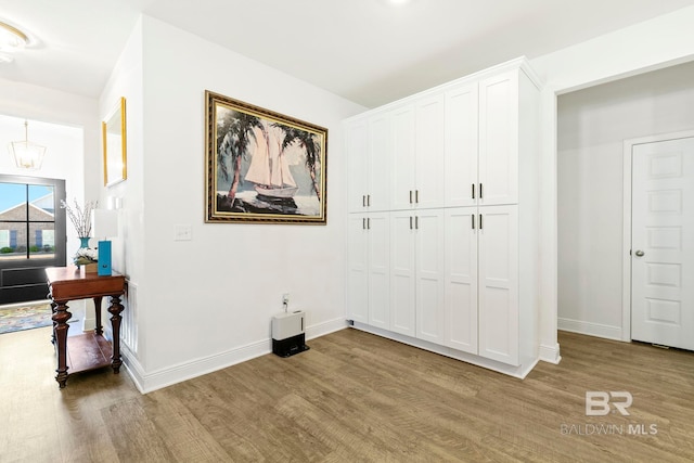 interior space with light hardwood / wood-style floors and an inviting chandelier