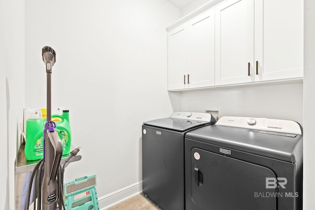 laundry area featuring washer and clothes dryer and cabinets