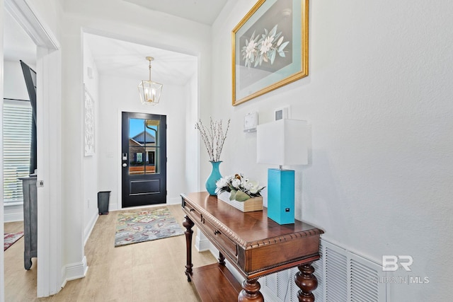 entrance foyer with a notable chandelier and light wood-type flooring