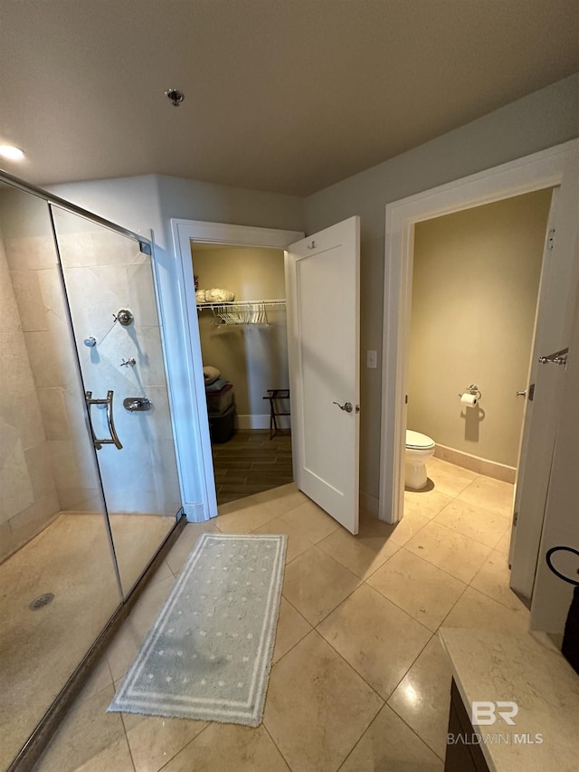 bathroom with tile patterned flooring, toilet, and walk in shower