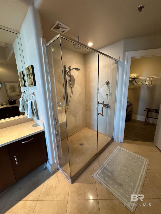 bathroom featuring an enclosed shower, vanity, and tile patterned flooring