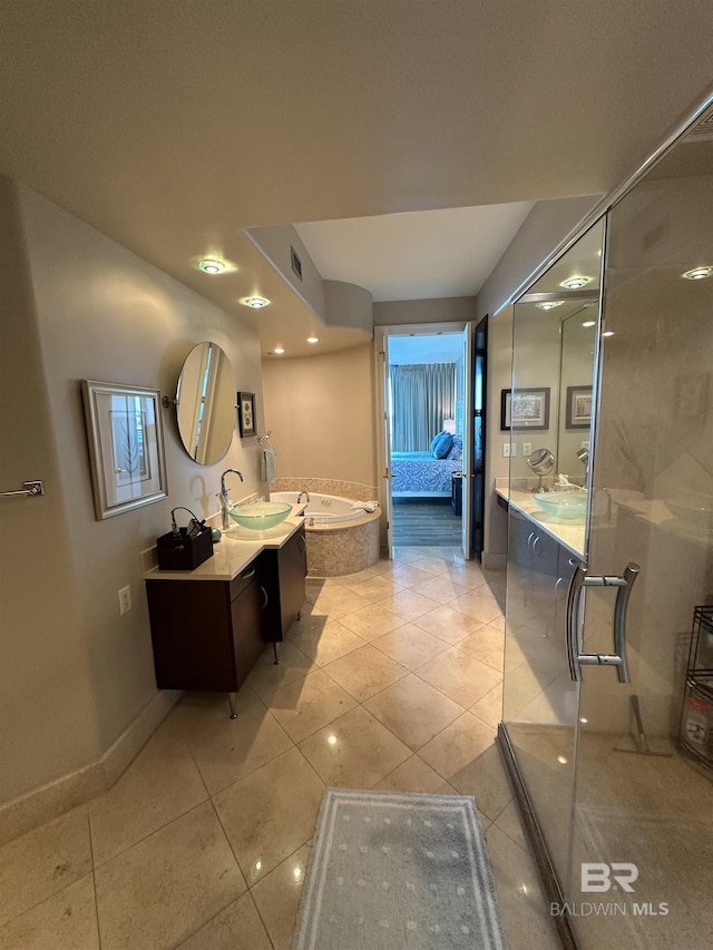 bathroom featuring tile patterned flooring, a tub to relax in, and vanity