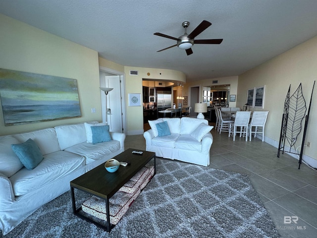 tiled living room featuring ceiling fan and a textured ceiling