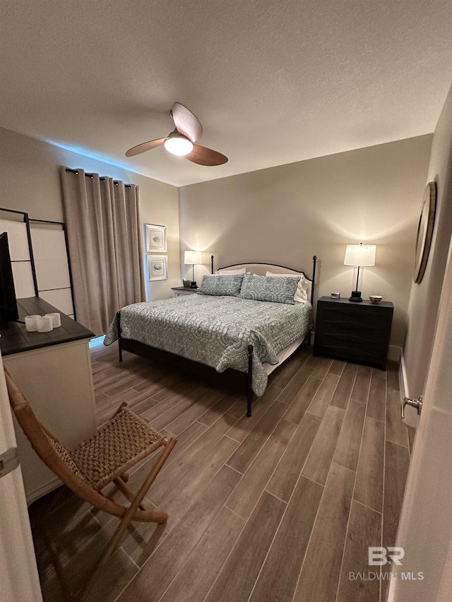 bedroom with wood-type flooring, a textured ceiling, and ceiling fan