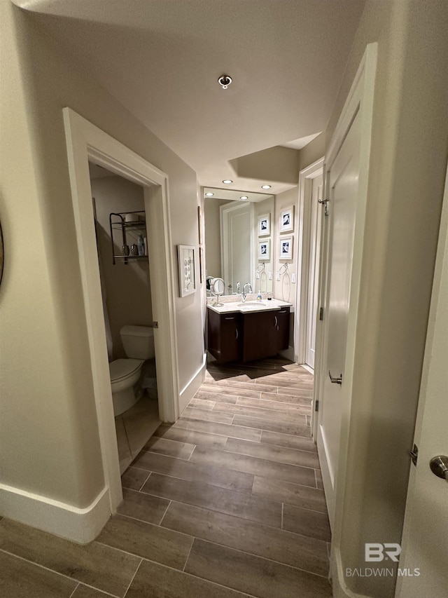 bathroom featuring vanity, wood-type flooring, and toilet