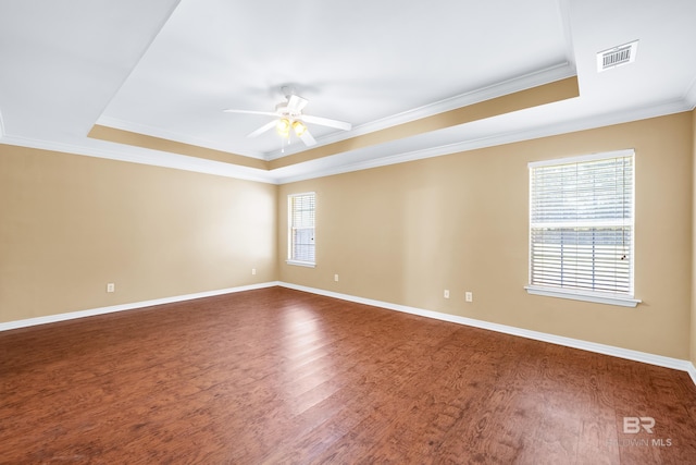 spare room featuring hardwood / wood-style floors, ceiling fan, crown molding, and a tray ceiling