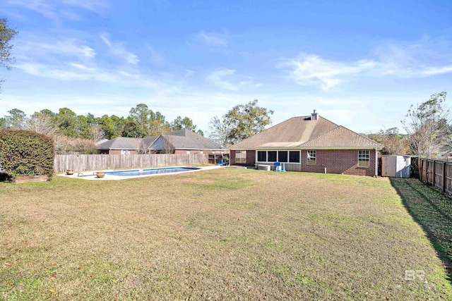 view of yard featuring a fenced in pool and a storage shed