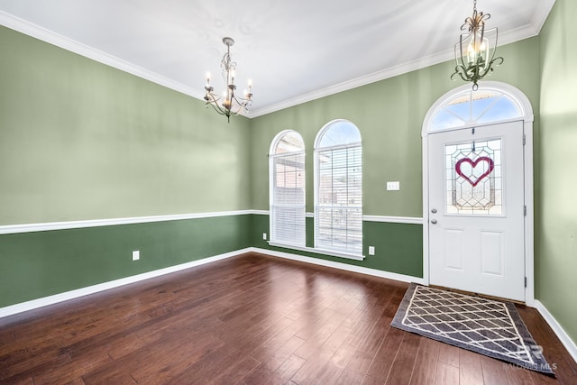 entrance foyer featuring ornamental molding, dark hardwood / wood-style floors, and an inviting chandelier