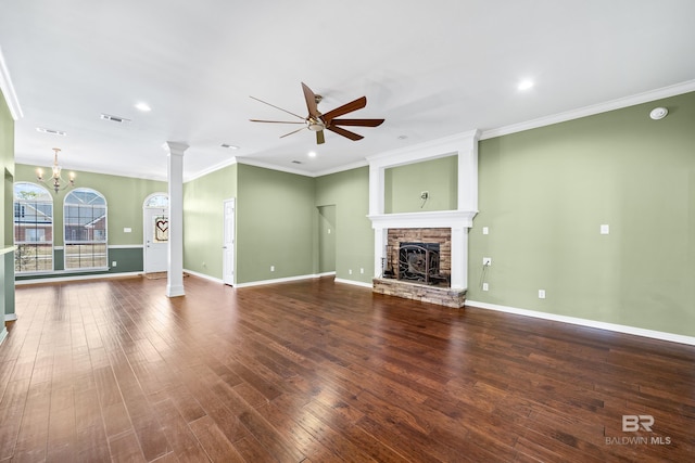 unfurnished living room with a stone fireplace, crown molding, dark hardwood / wood-style floors, and ceiling fan with notable chandelier