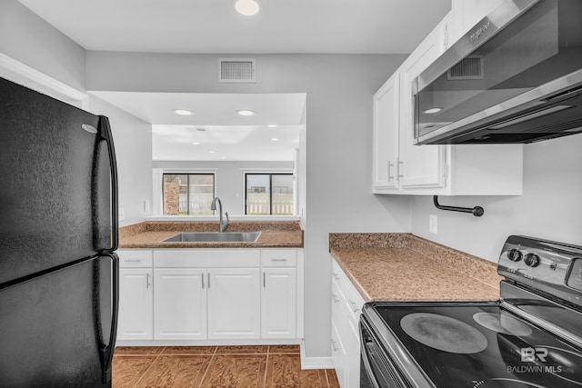 kitchen featuring black appliances, white cabinets, dark tile patterned flooring, sink, and dark stone countertops