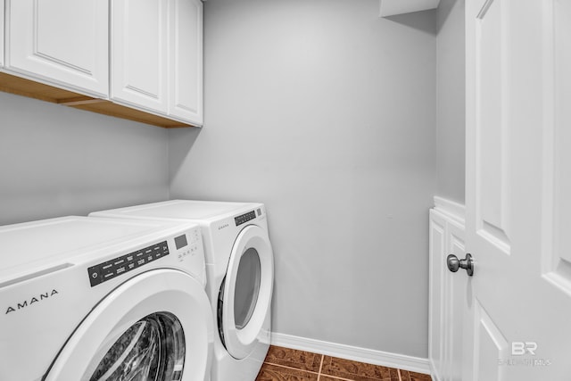 laundry area with dark tile patterned flooring, cabinets, and independent washer and dryer