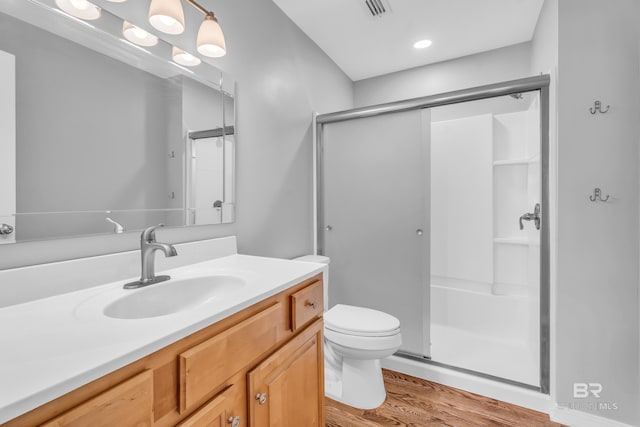 bathroom with vanity, hardwood / wood-style flooring, toilet, and an enclosed shower