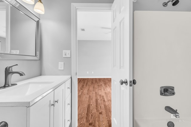 bathroom featuring vanity, wood-type flooring, and bathtub / shower combination