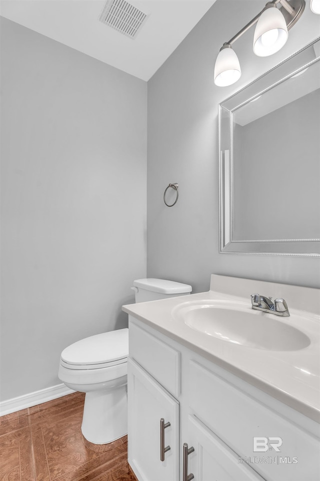 bathroom featuring vanity, toilet, and wood-type flooring