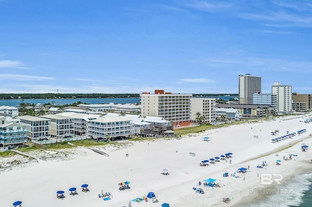 birds eye view of property with a water view and a beach view