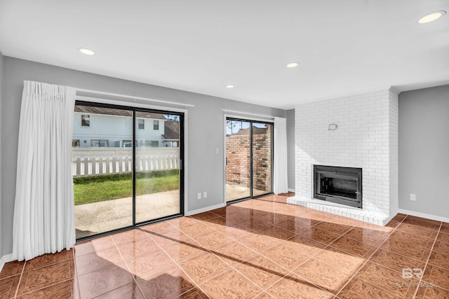 unfurnished living room featuring tile patterned flooring and a brick fireplace