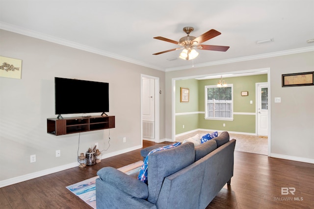 living room featuring ceiling fan with notable chandelier, dark wood-type flooring, and ornamental molding