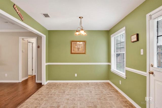 unfurnished room with crown molding, a wealth of natural light, light hardwood / wood-style flooring, and a notable chandelier