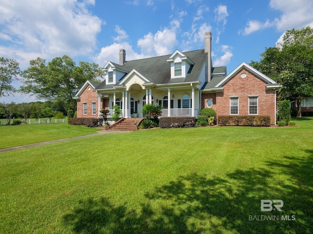 24235 County Road 87, Robertsdale, AL 36567 - cape cod-style house with a chimney, a porch, a front yard, and brick siding