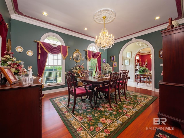 24235 County Road 87, Robertsdale, AL 36567 - dining space featuring arched walkways, ornamental molding, a chandelier, wood finished floors, and baseboards