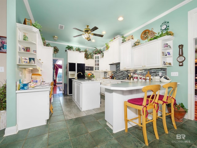 24235 County Road 87, Robertsdale, AL 36567 - kitchen featuring open shelves, tasteful backsplash, a peninsula, an island with sink, and ceiling fan