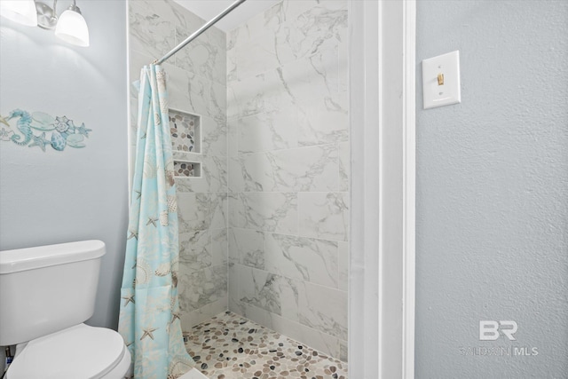 bathroom featuring curtained shower and toilet