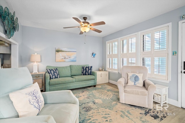 living room featuring ceiling fan, a healthy amount of sunlight, and light hardwood / wood-style flooring