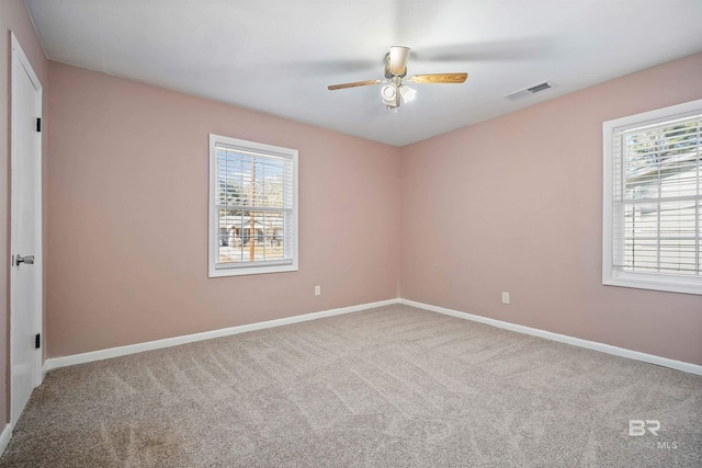 spare room featuring carpet floors, a wealth of natural light, and ceiling fan