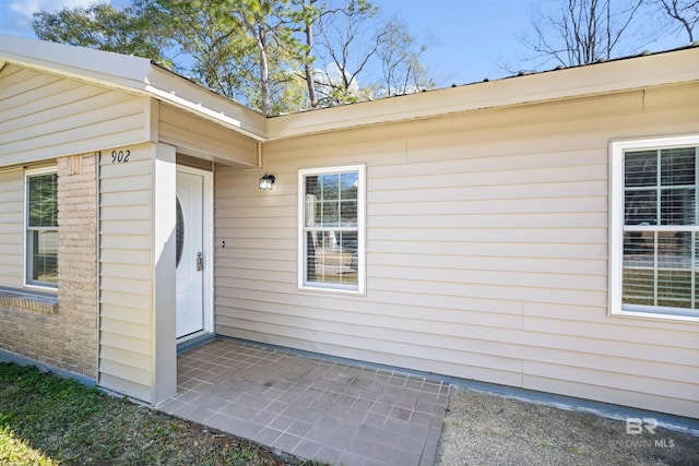 view of exterior entry with a patio