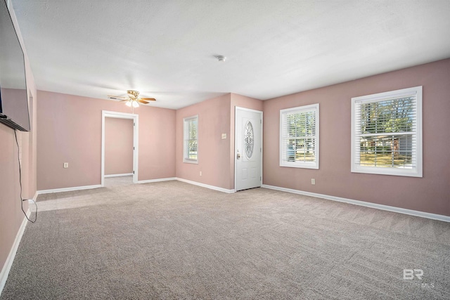 spare room with ceiling fan and light colored carpet