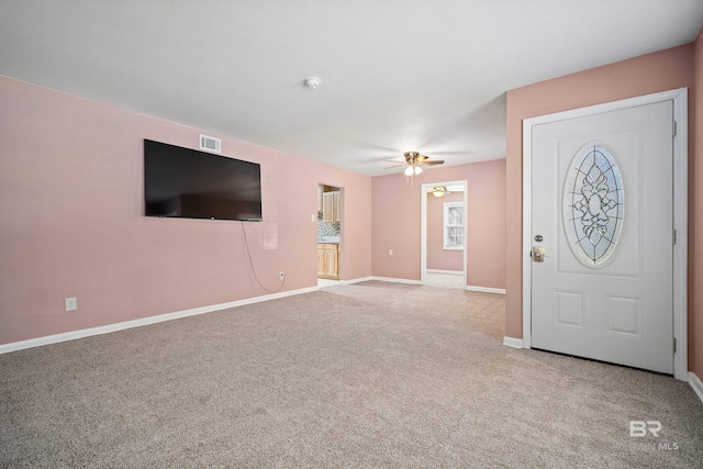 carpeted entryway featuring ceiling fan