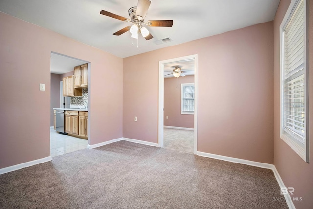 spare room featuring ceiling fan and light colored carpet