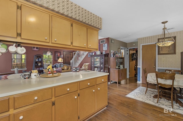 31375 Stagecoach Rd, Spanish Fort, AL 36527 - kitchen with wallpapered walls, light countertops, an accent wall, dark wood-style floors, and pendant lighting