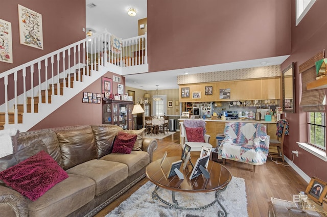 31375 Stagecoach Rd, Spanish Fort, AL 36527 - living room with wood finished floors, a towering ceiling, stairs, and baseboards