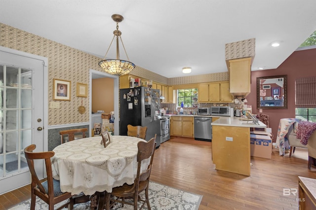 31375 Stagecoach Rd, Spanish Fort, AL 36527 - kitchen featuring stainless steel appliances, wallpapered walls, a peninsula, light countertops, and light wood-type flooring