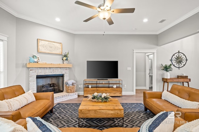 living room featuring crown molding, ceiling fan, hardwood / wood-style floors, and a brick fireplace